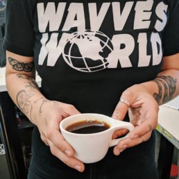 A cup of black coffee from Dark Horse held in someone's hands