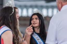 A girl in a tiara looks at her friend